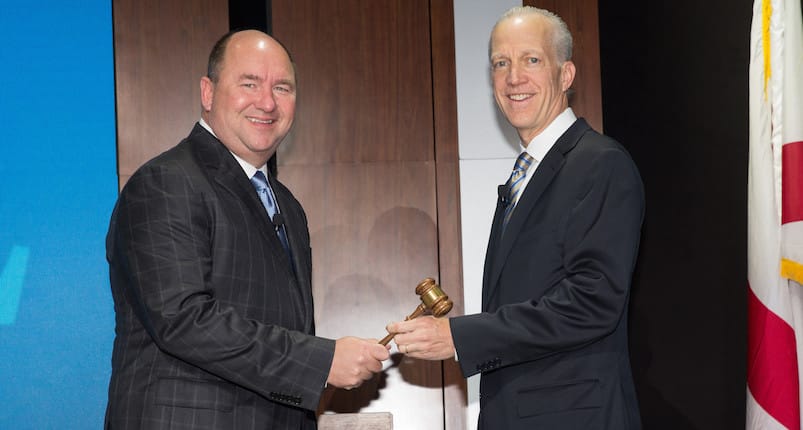 Outgoing NACDS chairman Randy Edeker of Hy-Vee hands the gavel to his successor, H-E-B's Martin Otto.